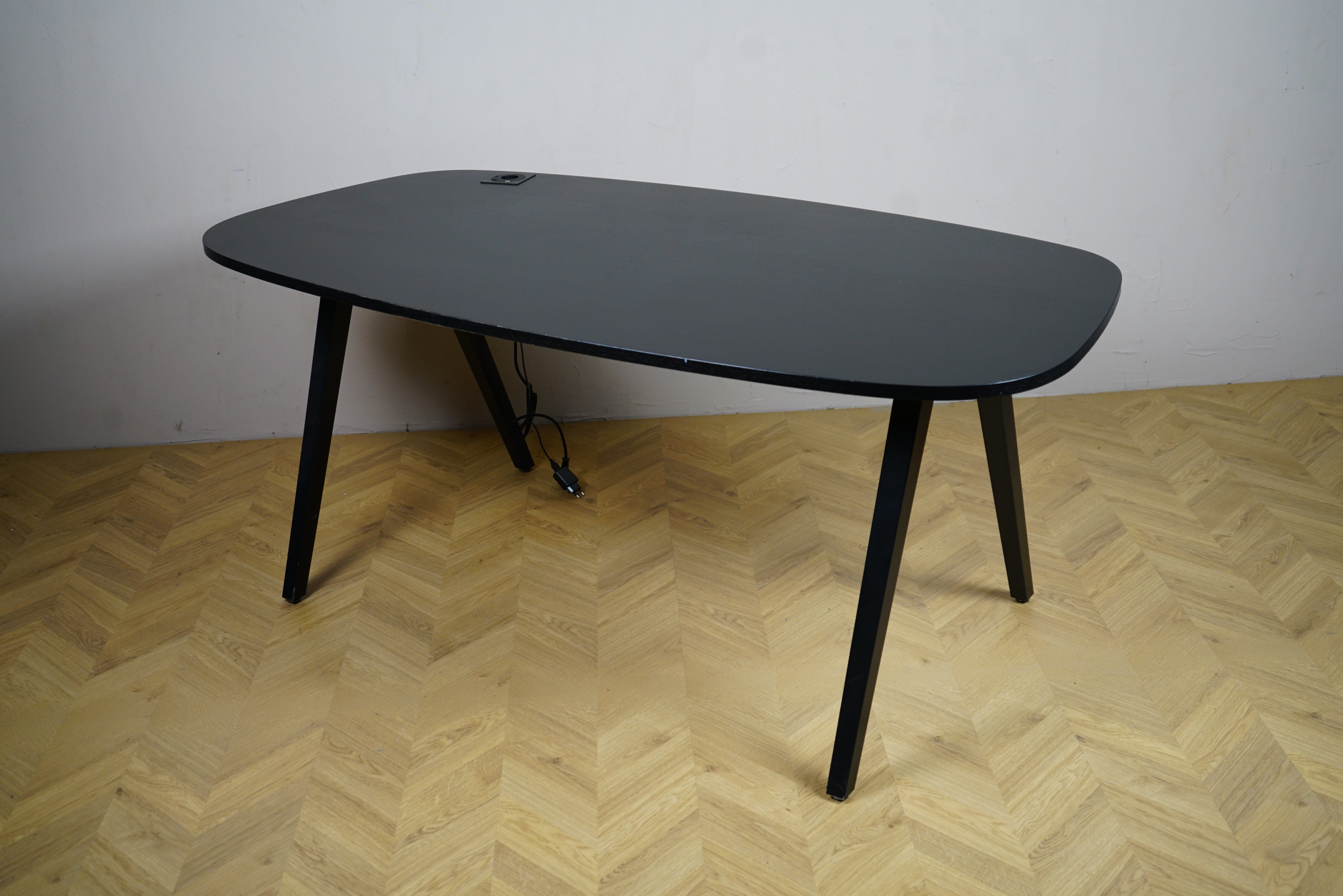 Kinnarps Oberon sort skrivebord 180x90 cm set fra skrå vinkel – moderne kontorbord med minimalistisk design og robuste ben.